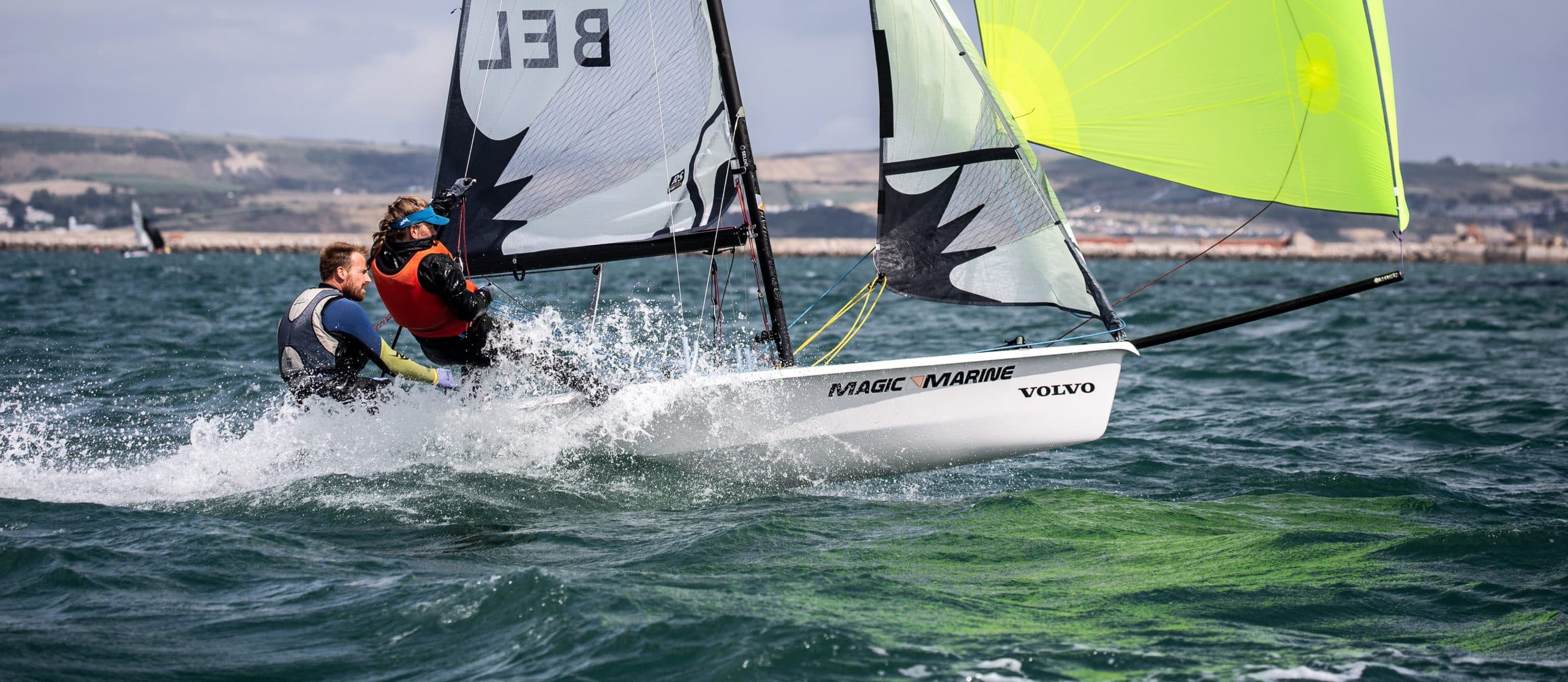 Belgian RS500 planing downwind under a lime-green spinnaker